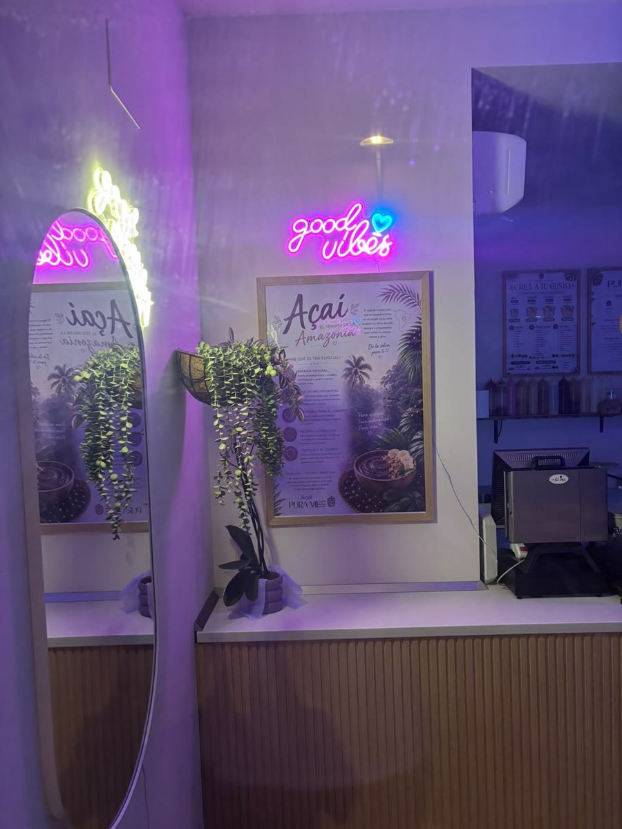 El escaparate de noche, con el neón good vibes encendido